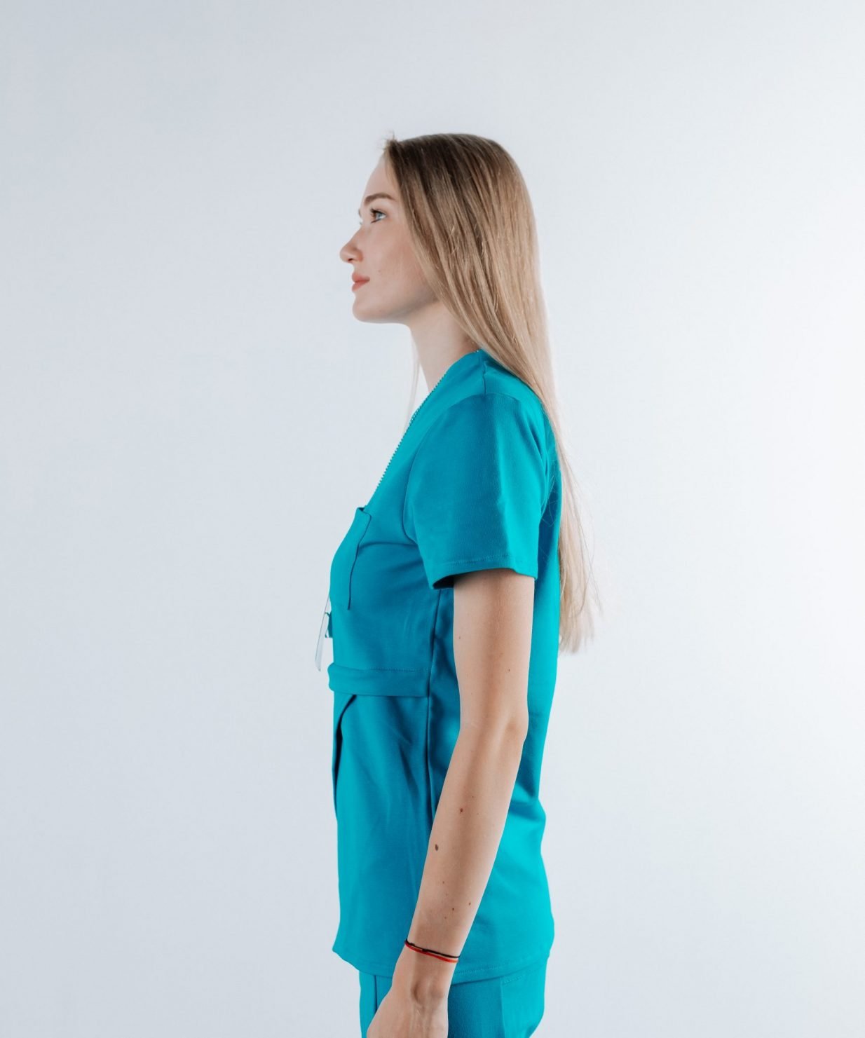 scrub medical albastru azure uniforma doctori costum spital studenti medicina14 scaled Vedere laterala a unei doamne doctor ce poarta o bluza edgy de scrub medical albastru azure.Uniforma medicala albastru azure este din bumbac 95% si elastan 5% cu croiala fit.