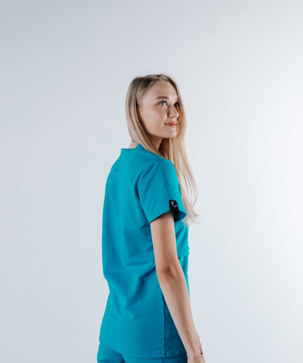 scrub medical albastru azure uniforma doctori costum spital studenti medicina15 scaled Doamna doctor ce poarta o bluza tunica de scrub medical albastru azure.Uniforma medicala albastru azure este din bumbac 95% si elastan 5% cu croiala fit.