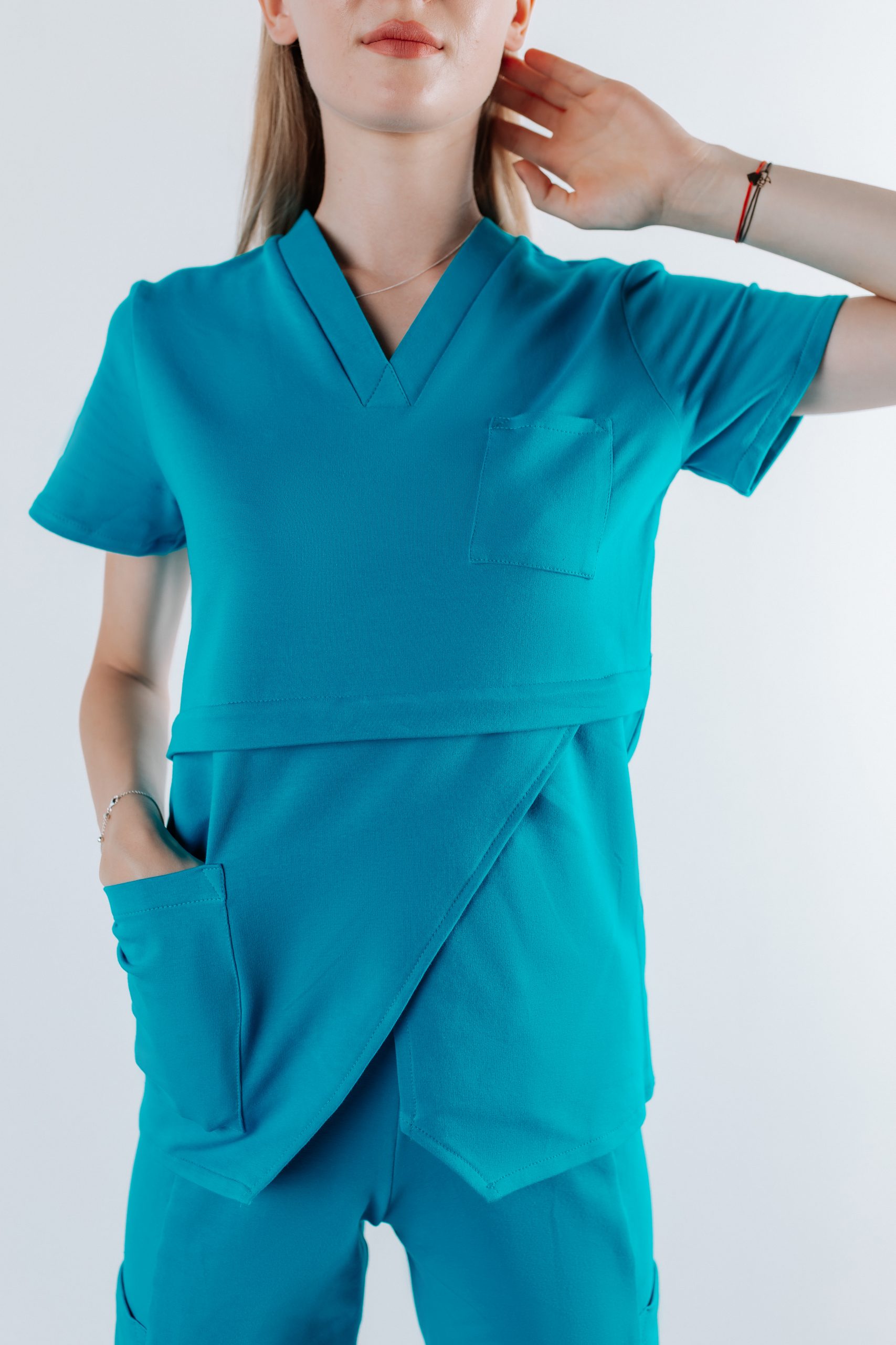 Doamna doctor ce poarta o bluza edgy de scrub medical albastru azure.Uniforma medicala albastru azure este din bumbac 95% si elastan 5% cu croiala fit.