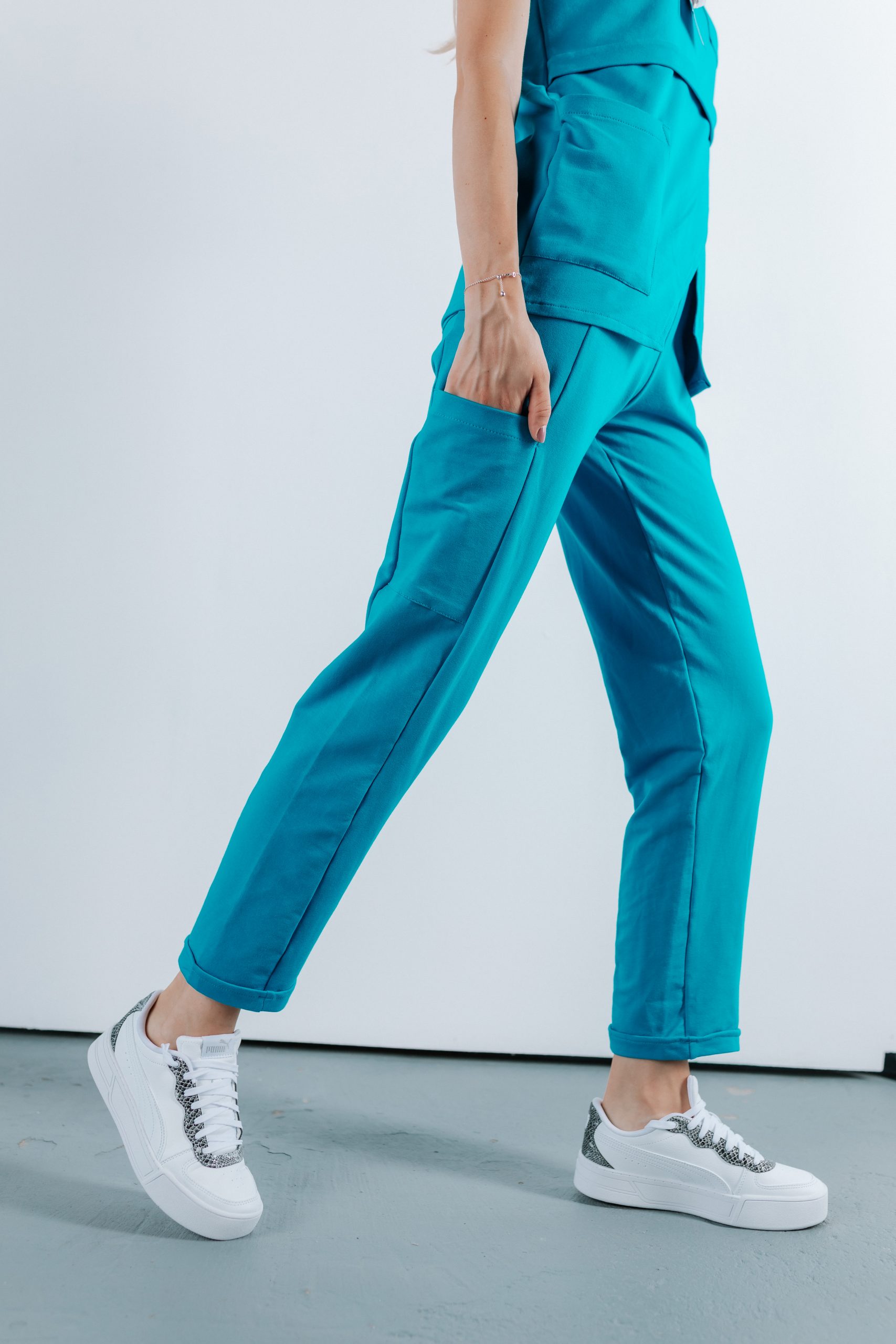 Doamna doctor ce poarta pantaloni de scrub medical albastru azure.Uniforma medicala albastru azure este din bumbac 95% si elastan 5% cu croiala fit.