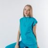 Doamna doctor ce poarta o bluza tunica de scrub medical albastru azure.Uniforma medicala albastru azure este din bumbac 95% si elastan 5% cu croiala fit.