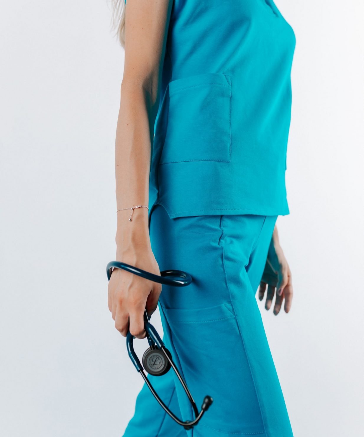 Doamna doctor ce poarta o bluza de scrub medical albastru azure.Uniforma medicala albastru azure este din bumbac 95% si elastan 5% cu croiala fit.