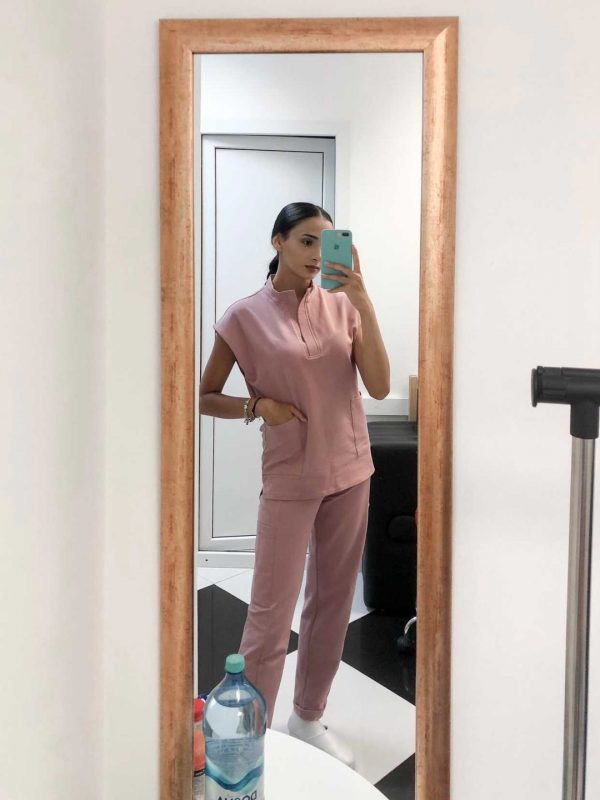 Fotografie cu vedere din profil a unei cliente in timp ce poarta o bluza tunica un scrub medical roz pudra ce reprezinta uniforma medicala reprezentativa a unui doctor